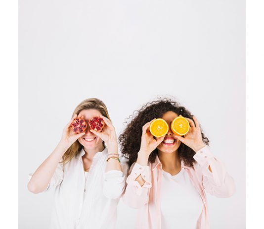 Two happy women having fruits for stress relief